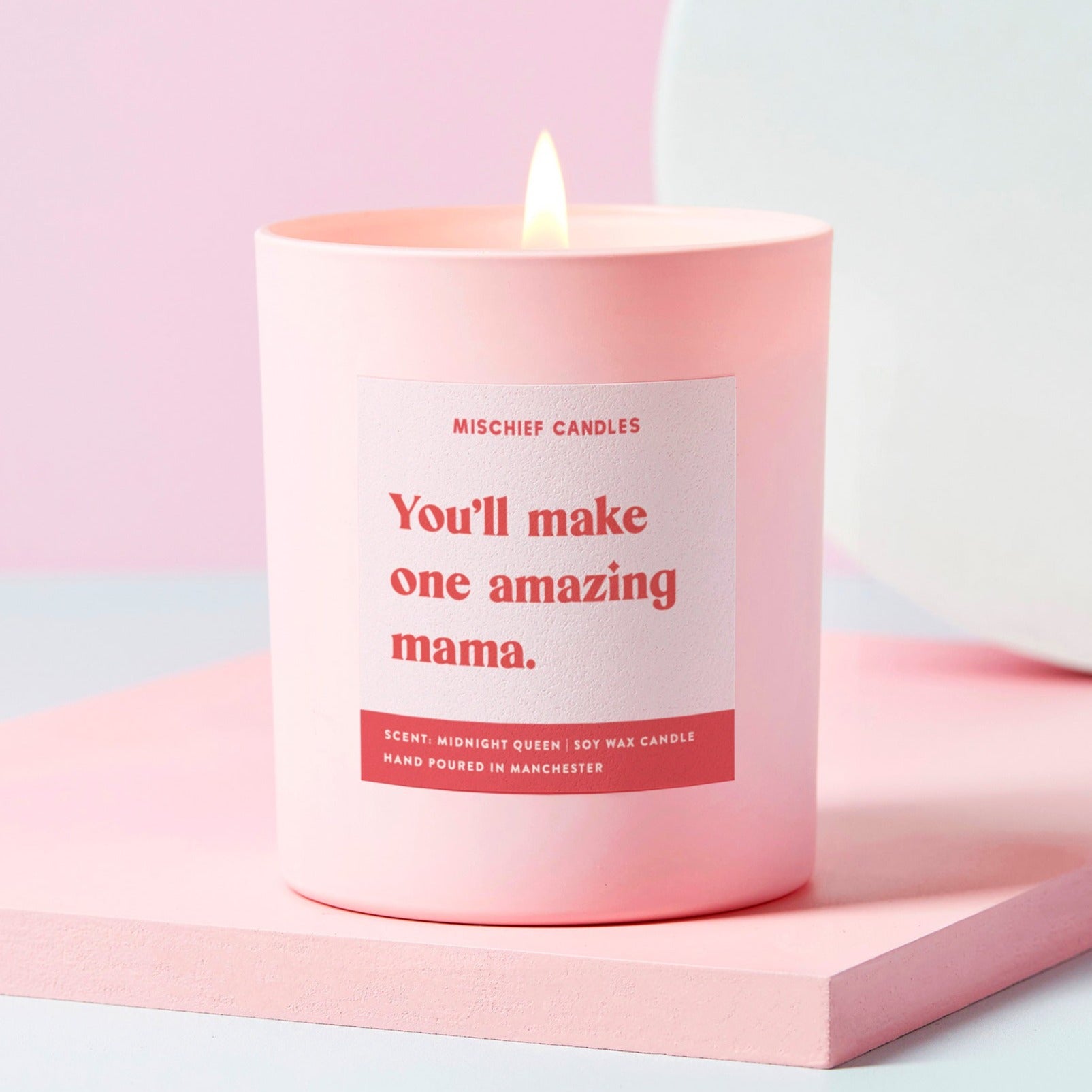 Pink candle with a label on a light pink background