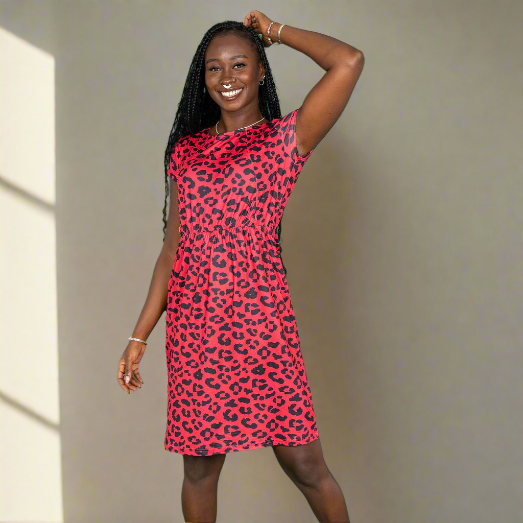 Woman wearing a pink leopard print dress against a neutral background
