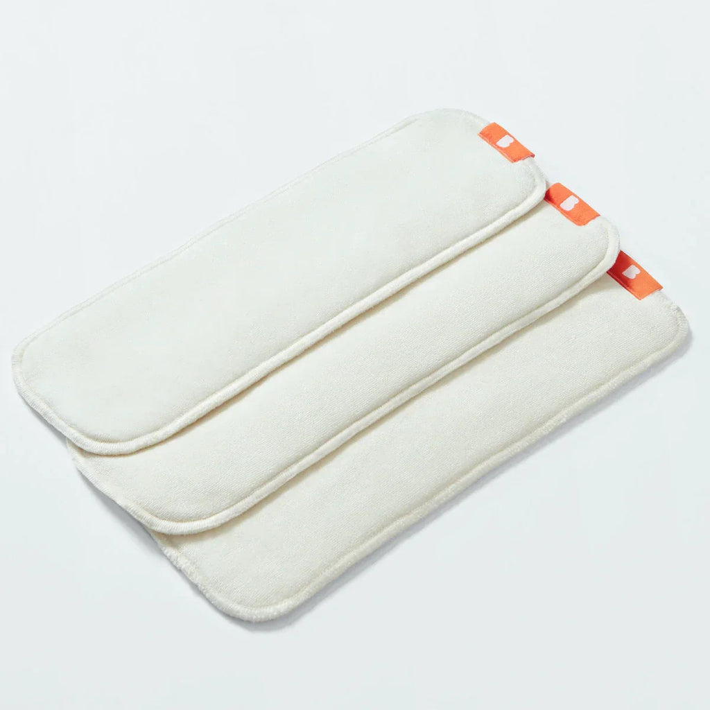 White nappy liner booster pad with orange accents on a light gray background