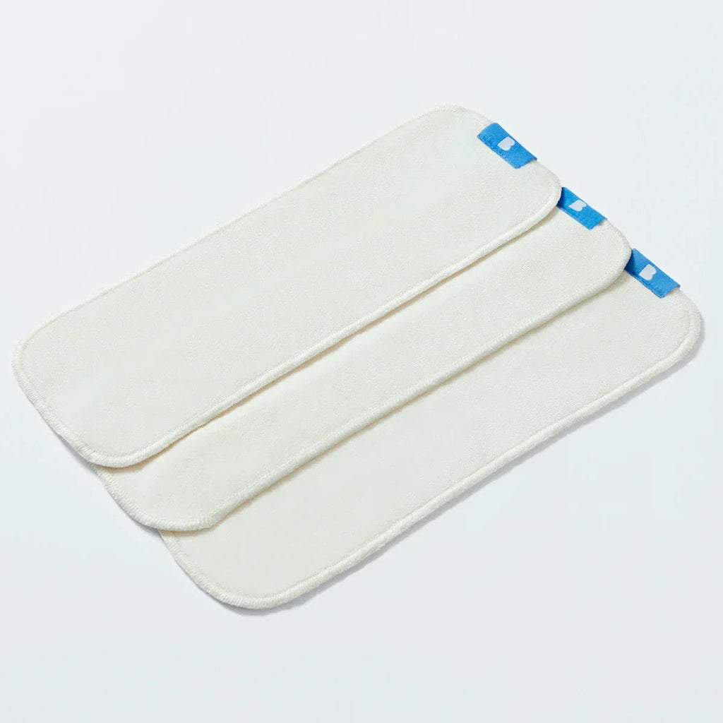 White nappy boosters with blue accents on a light gray background