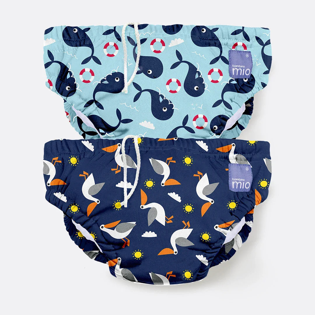 Two swim diapers with whale and bird patterns on a white background